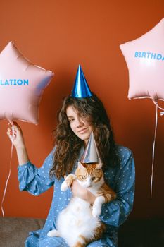 一位戴着气球派对帽、抱着猫的女性，非常适合生日庆祝活动