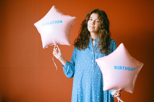 Woman Holding Pink Star Shaped Balloons while Smiling at the Camera