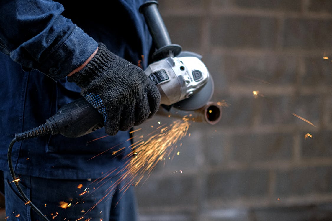 A Person Using a Grinder on a Metal