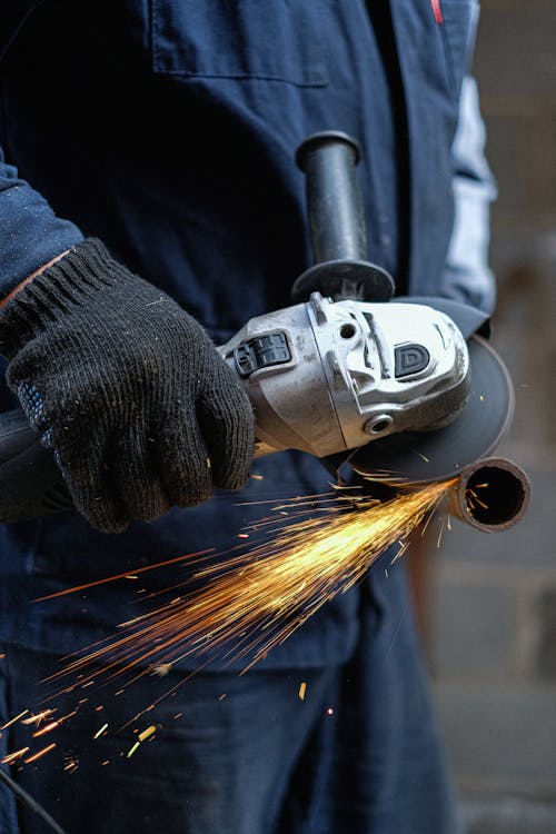 A Hand Cutting a Metal Using an Angle Grinder
