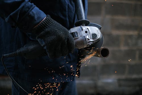 A Person Using a Black Corded Power Tool