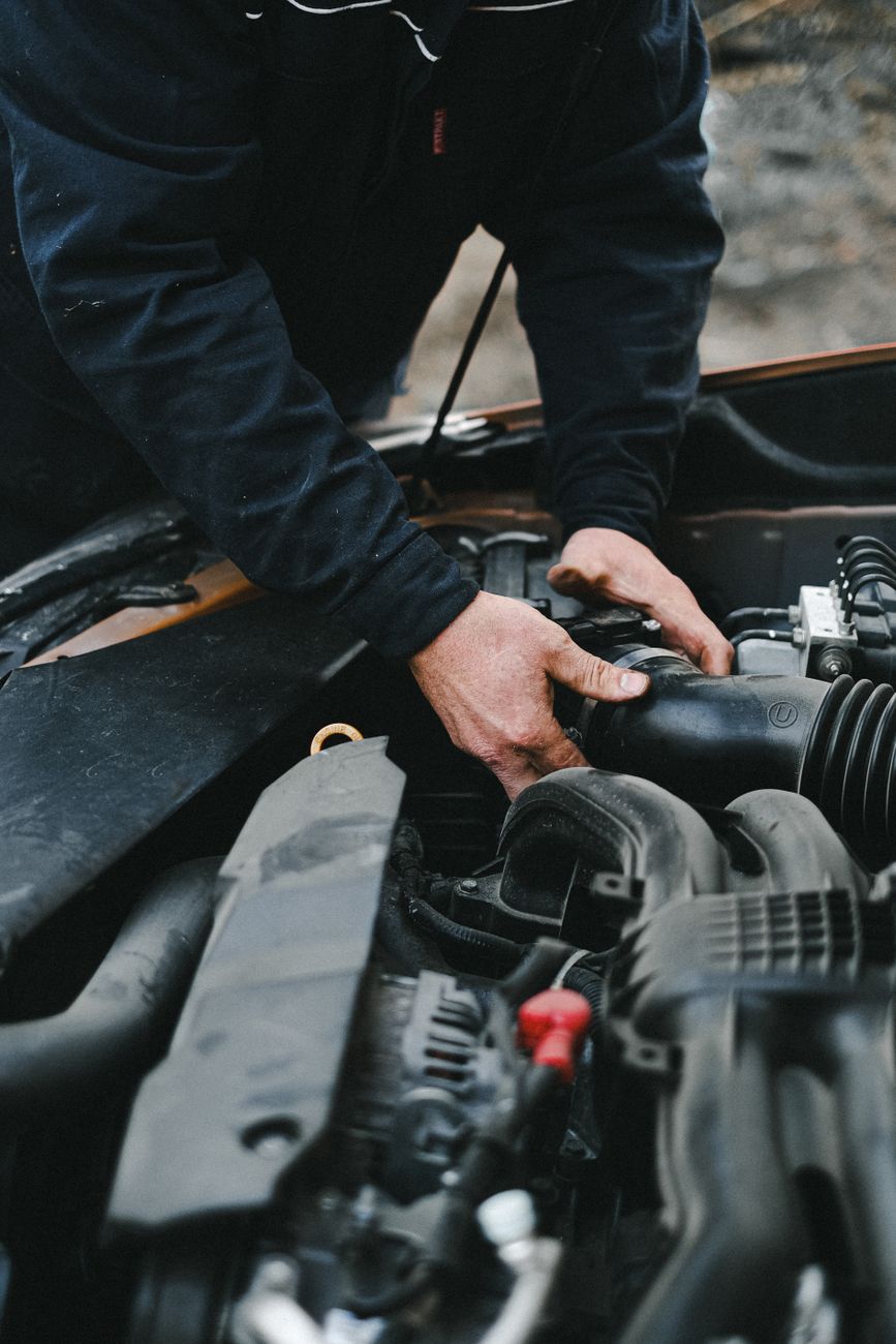 Close-up of a mechanic's hands working on a car engine