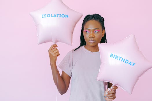 A woman holding star-shaped balloons with 'isolation' and 'birthday' on a pink background, reflecting modern social experiences.