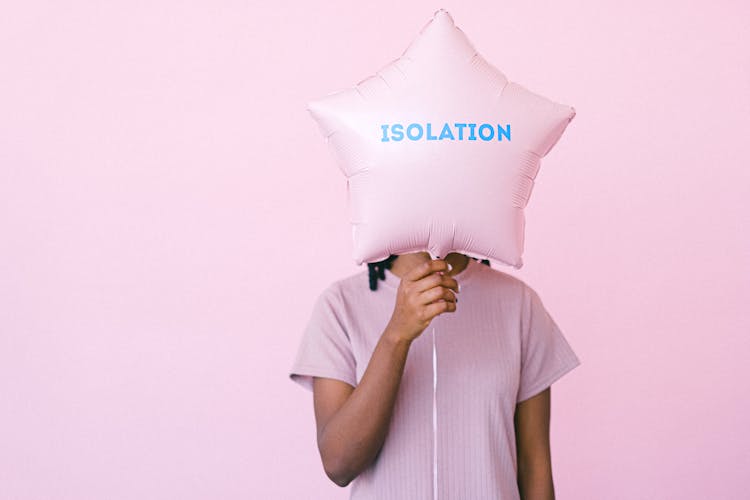 A Person Covering Her Face Using The Star Shaped Balloon She Is Holding