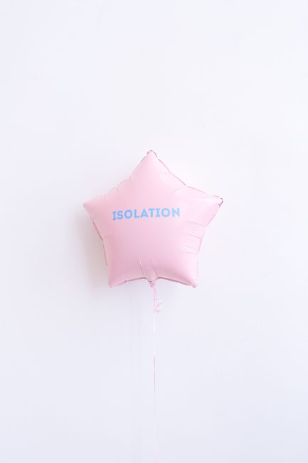 Pink star shaped balloon displaying the word 'Isolation' on a white background.