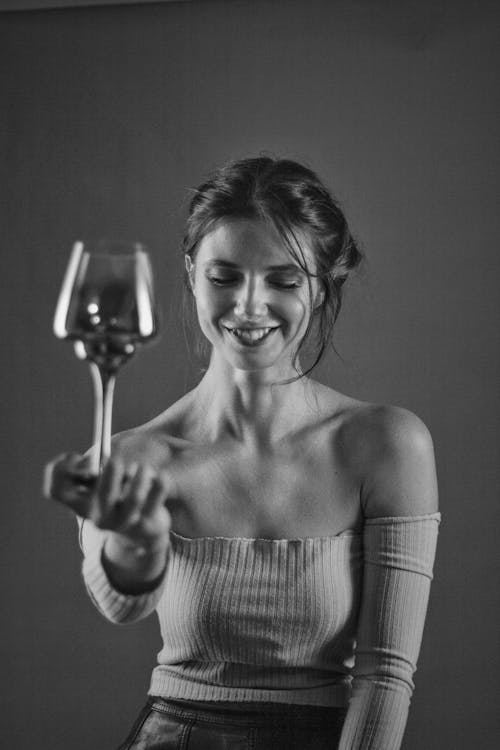 Grayscale Photo of a Woman Holding a Glass of Champagne