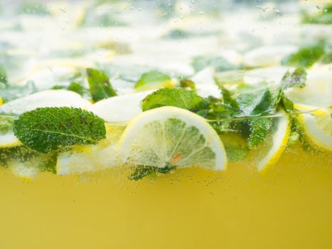 A vibrant close-up of lemon slices and mint leaves submerged in refreshing water, evoking a sense of freshness.