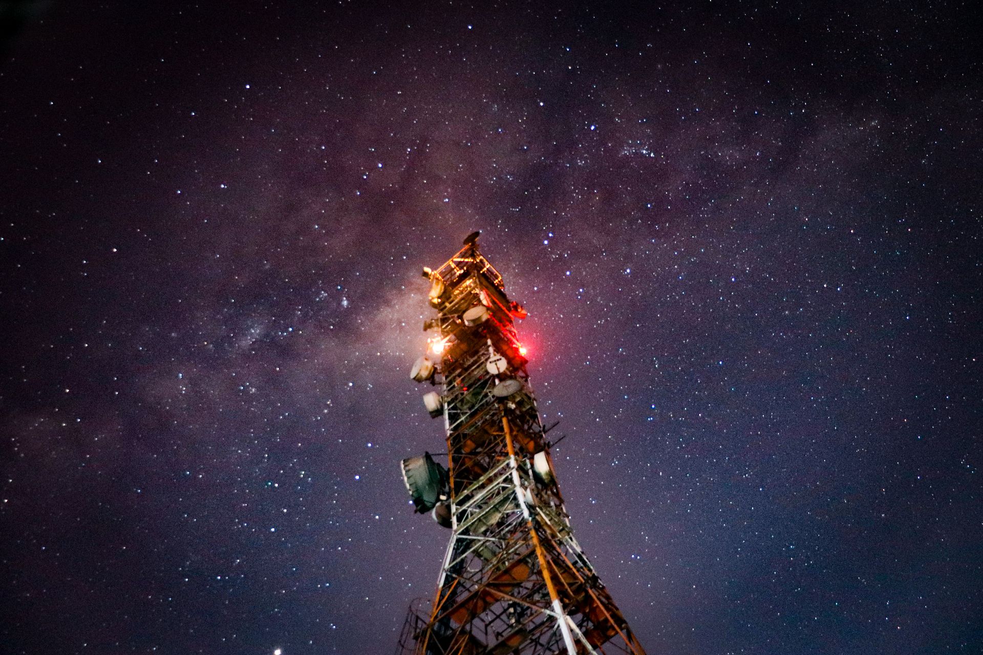 Night shot of a communication tower against a starry sky, showcasing connectivity and the cosmos.