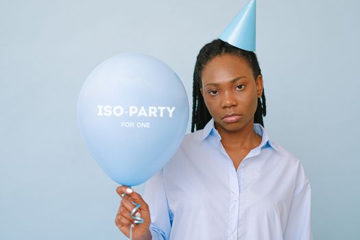 A Sad Woman Wearing Party Hat while Holding a Blue Balloon