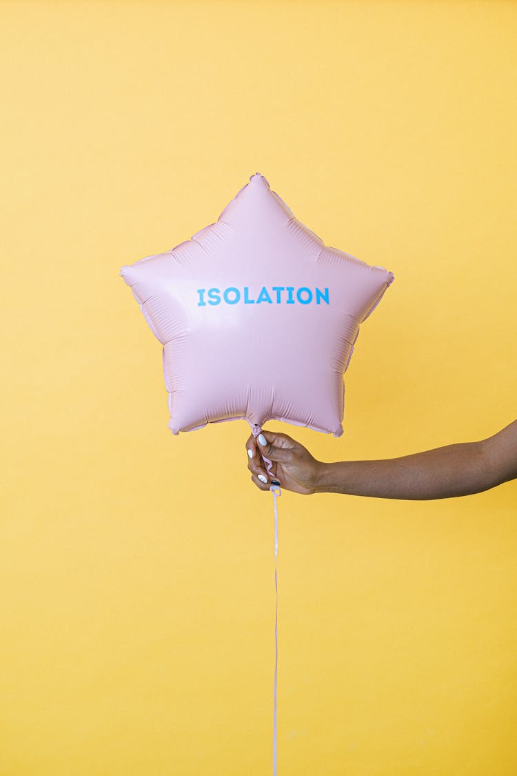 A Person Holding A Pink Star Shaped Balloon In Yellow Background