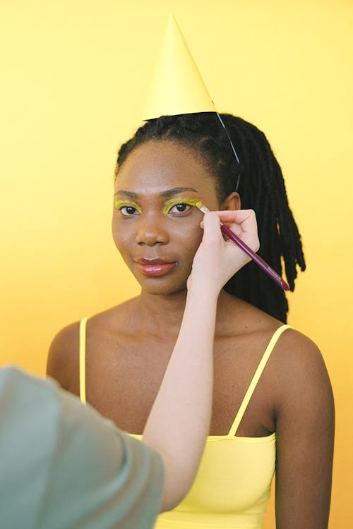 Foto profissional grátis de aplicando, fundo amarelo, maquiagem