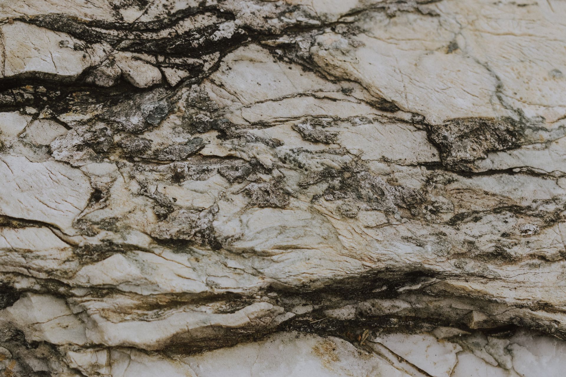 Close-up view of a natural stone texture with visible cracks and details, suitable for backgrounds.