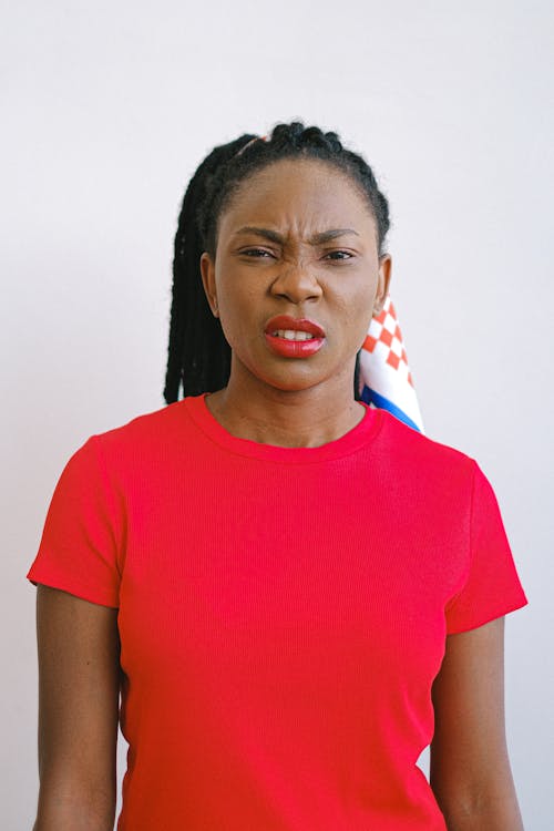 Woman in Red Shirt and Lipstick Looking Disgusted