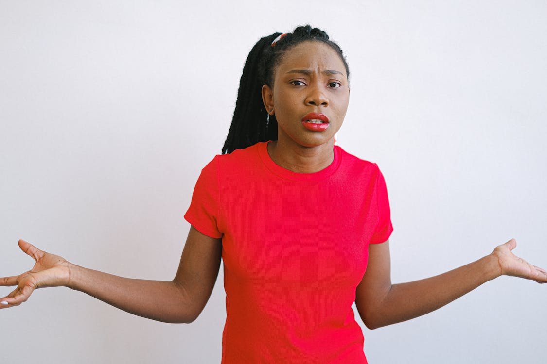 Free Girl in Red Crew Neck Shirt Looking Confused Stock Photo