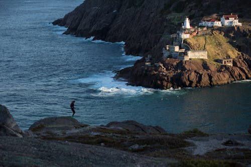 無料 崖の上に立っている人のシルエット写真 写真素材