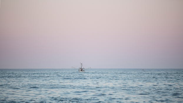 在宁静的暮光下，一艘孤独的渔船航行在平静的海面上，营造出一片宁静的海景