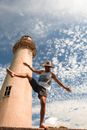 Unrecognizable tourist dancing near old lighthouse under cloudy sky
