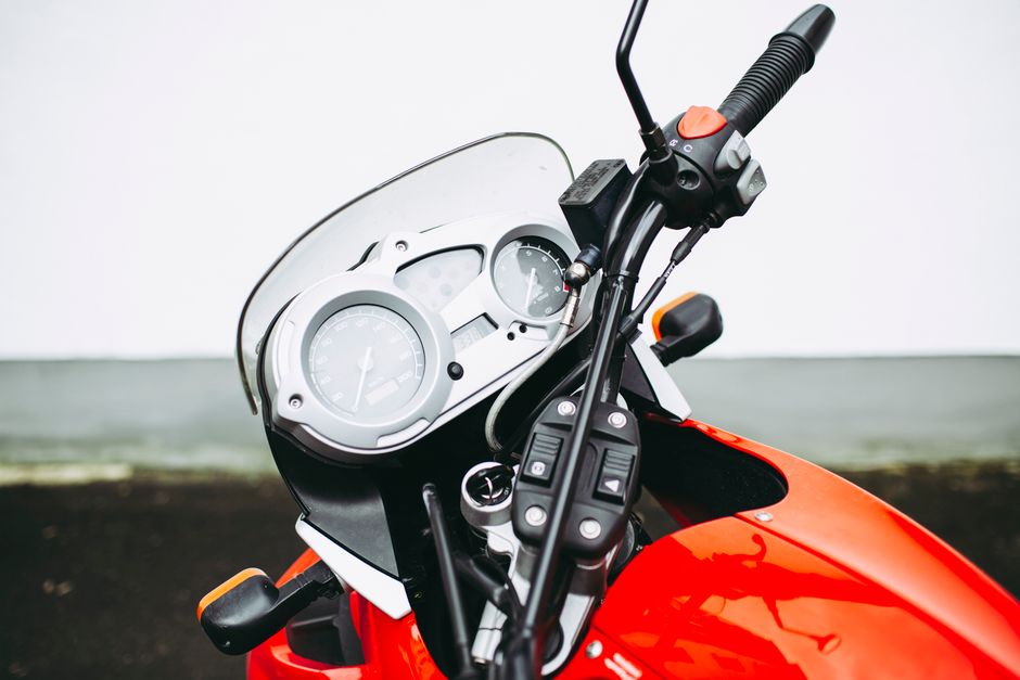 Detailed view of a motorcycle's handlebar and dashboard, showcasing gauges and controls.