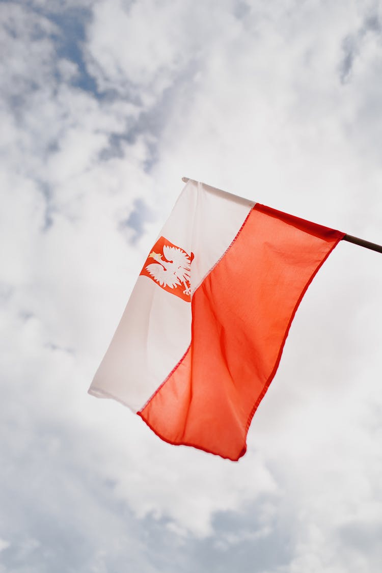 Colorful Flag Of Republic Of Poland Under Cloudy Sky