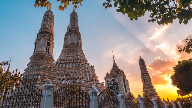 Beautiful sunset over Wat Arun, showcasing its intricate architecture in Bangkok, Thailand.