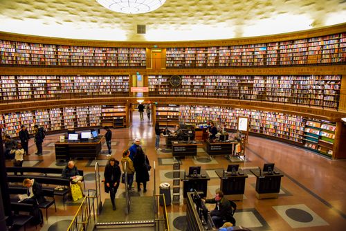 Public Library View Modern public library with anonymous employees and visitors in hall ...