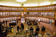 Unrecognizable visitors in public library with literature collection