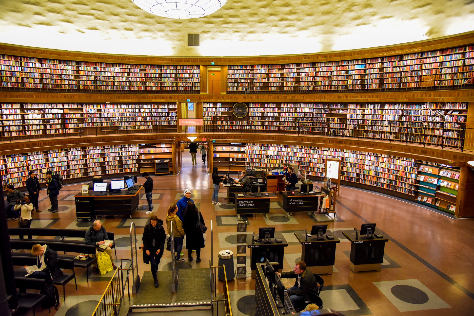 Vibrant view inside Stockholm Public Library showing visitors and bookshelves.
