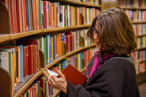 Anonymous woman reading book in city library