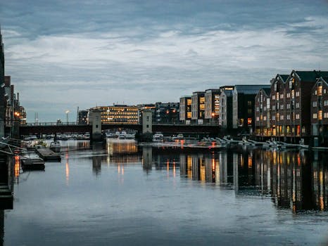 Stunning evening view of Trondheim's urban architecture reflecting in the calm river waters.