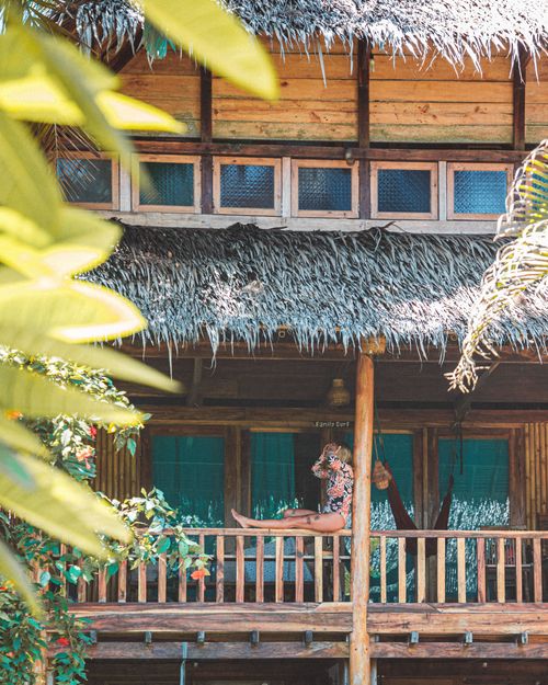 Free Relaxing scene of a woman at a tropical villa surrounded by greenery. Stock Photo
