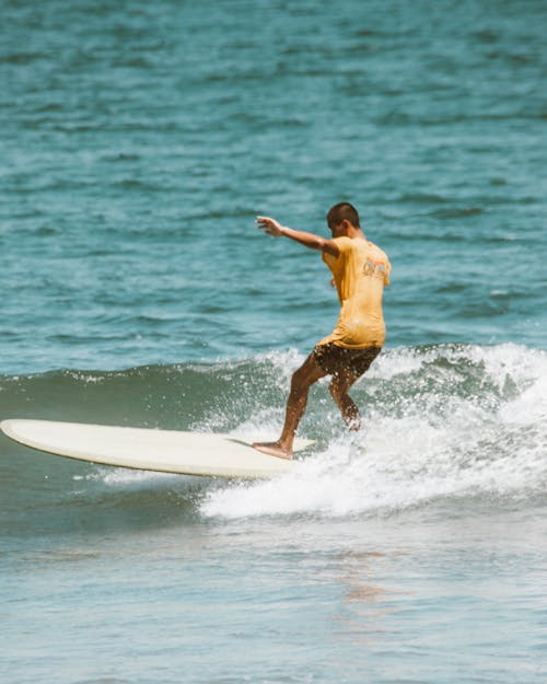 A Man Surfing on the Beach