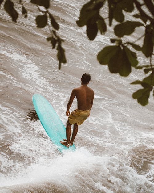 A Man Standing on His Surfboard