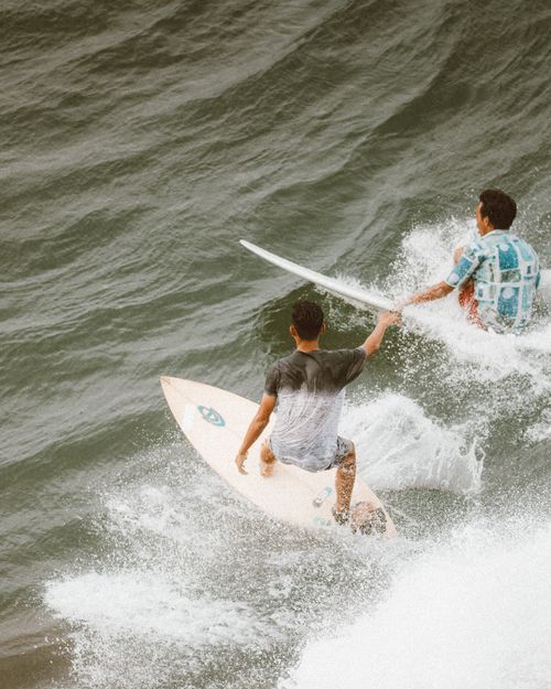 Free Two surfers navigating ocean waves, showcasing exciting watersport action. Stock Photo