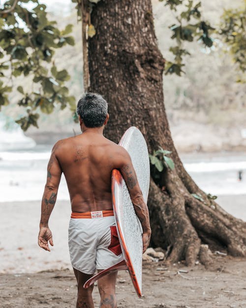 A Man Holding His Surfboard