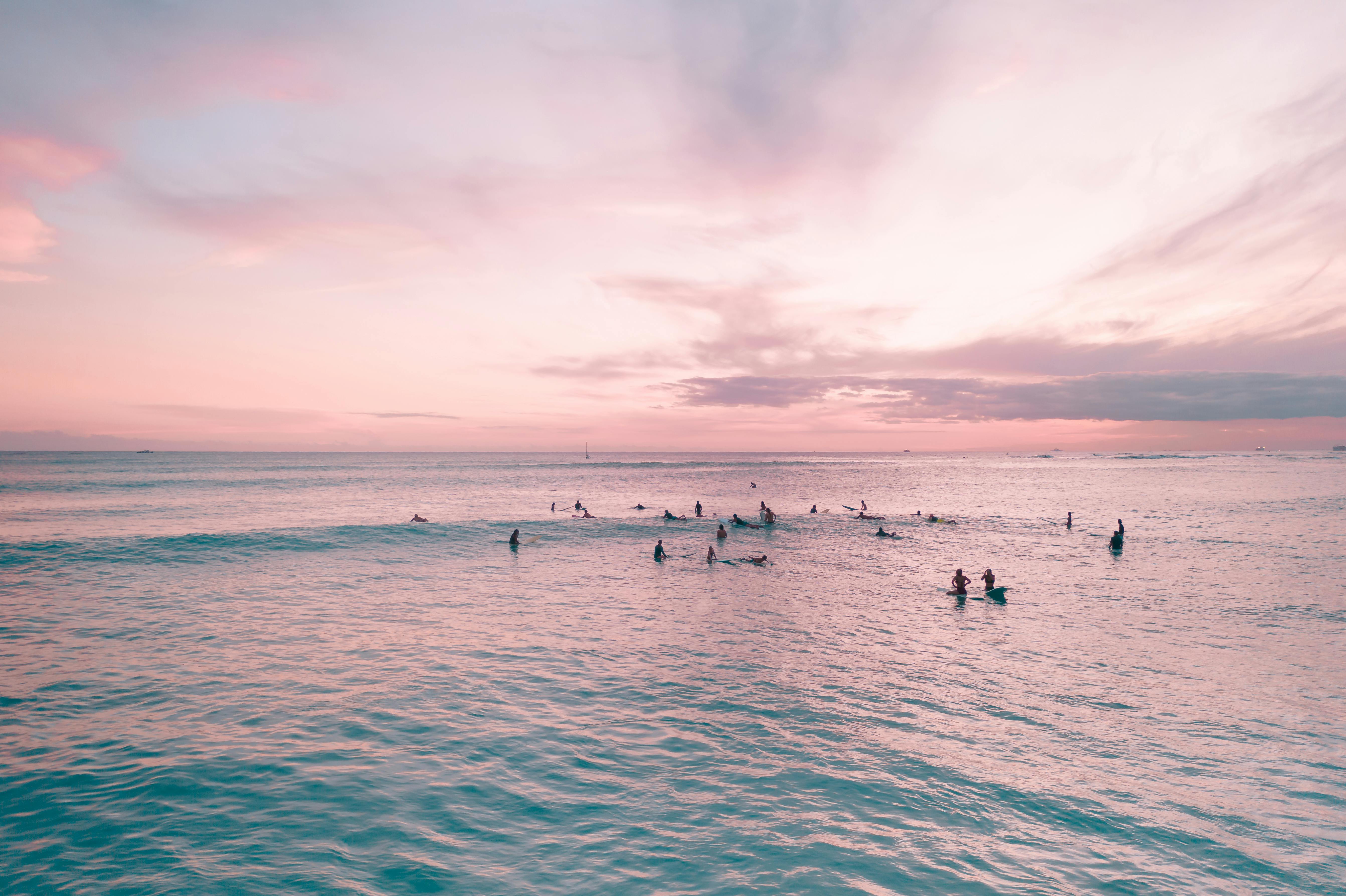 在夏威夷檀香山充满活力的日落时分，威基基海滩上浮现出冲浪者的剪影