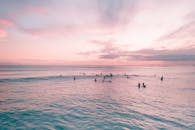 在夏威夷檀香山充满活力的日落时分，威基基海滩上浮现出冲浪者的剪影