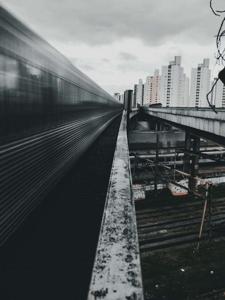 Express Train Driving On Railway Behind Multistory Buildings