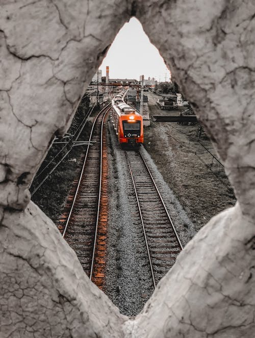 Contemporary bright train driving on railroad in suburb