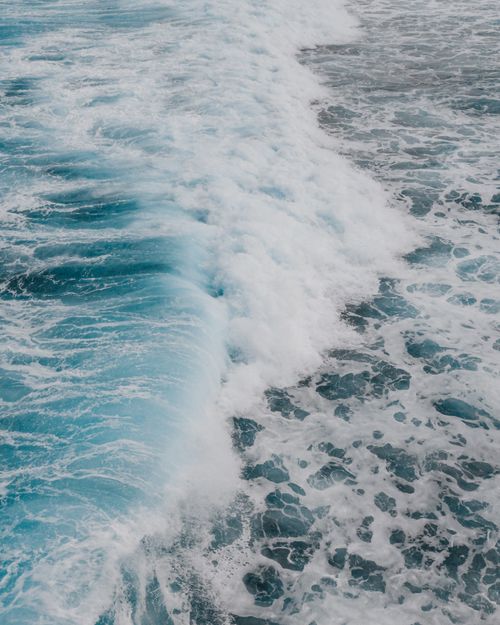 Free A breathtaking aerial view of blue ocean waves crashing on a Hawaiian shore. Stock Photo