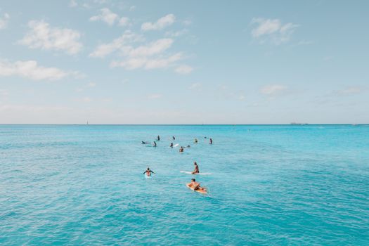 A group of surfers enjoying the clear blue waters of Hawaii. Perfect for travel and beach themes.