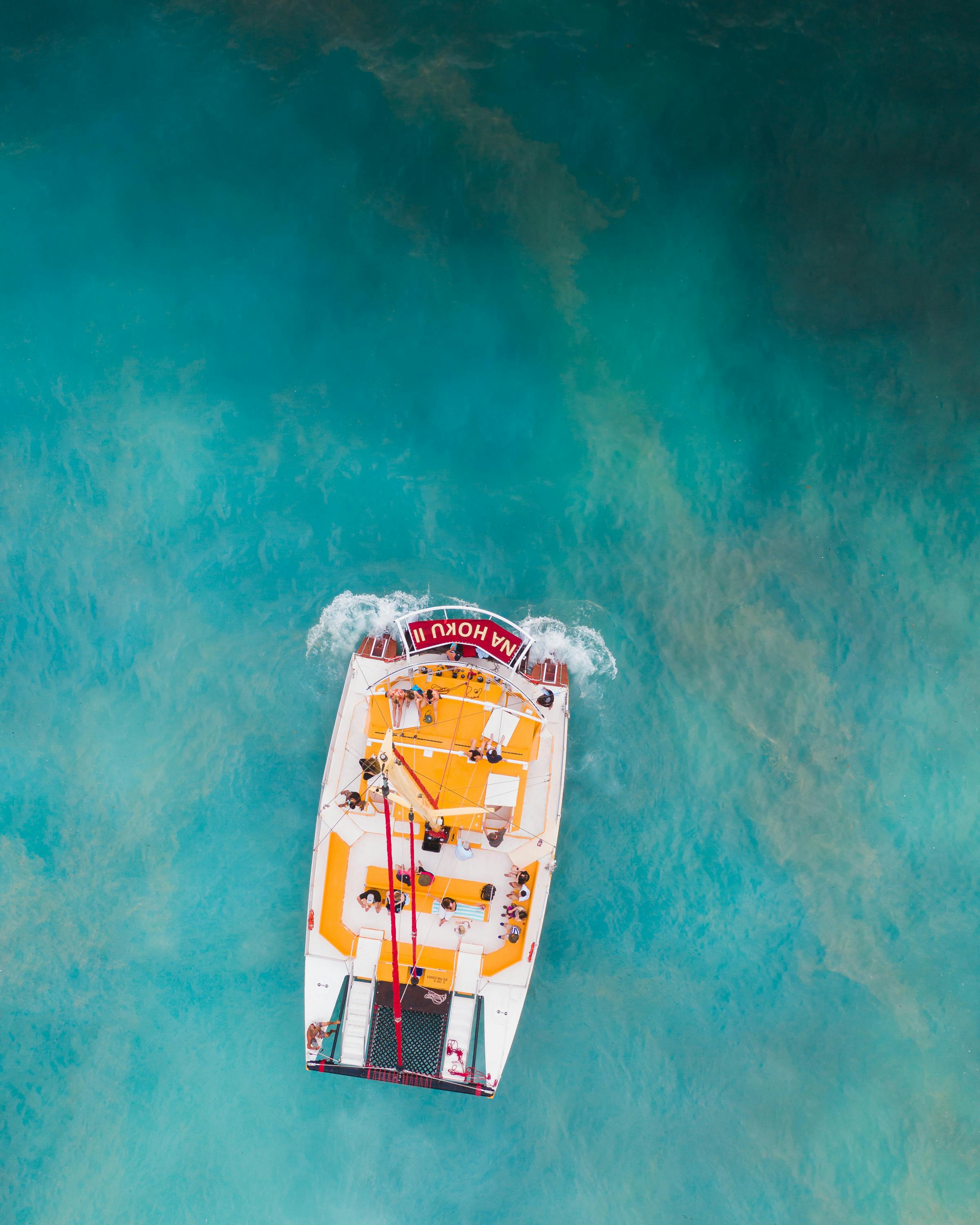 people riding on yellow and red boat on water