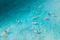 无人机捕捉到了在夏威夷檀香山附近享受清澈蔚蓝海水的冲浪者