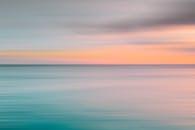 日落时宁静的海景，地平线上柔和的色彩