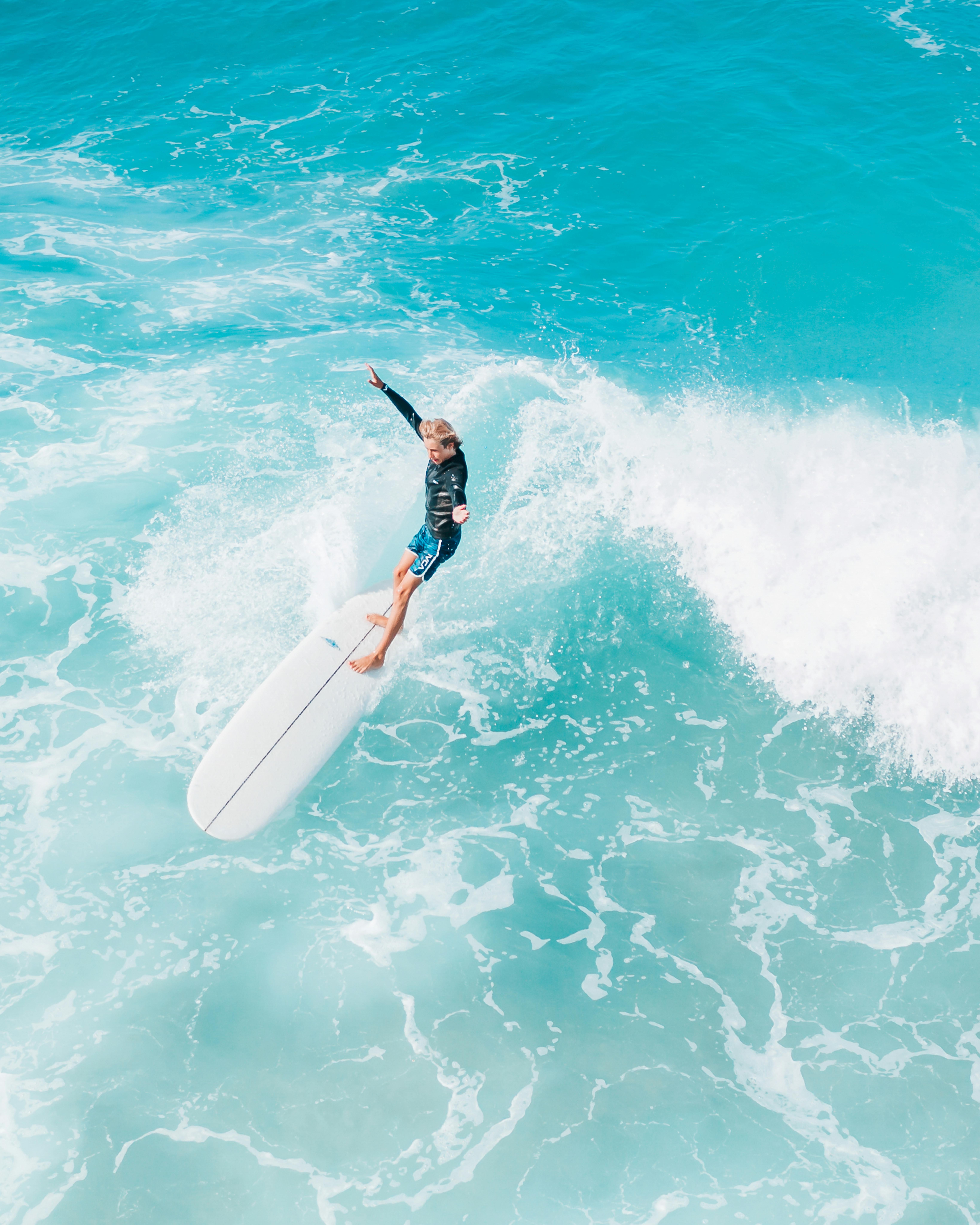 man surfing on blue water