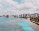 从空中视角探索夏威夷瓦胡岛威基海滩，感受其充满活力的城市景观与碧绿的海水