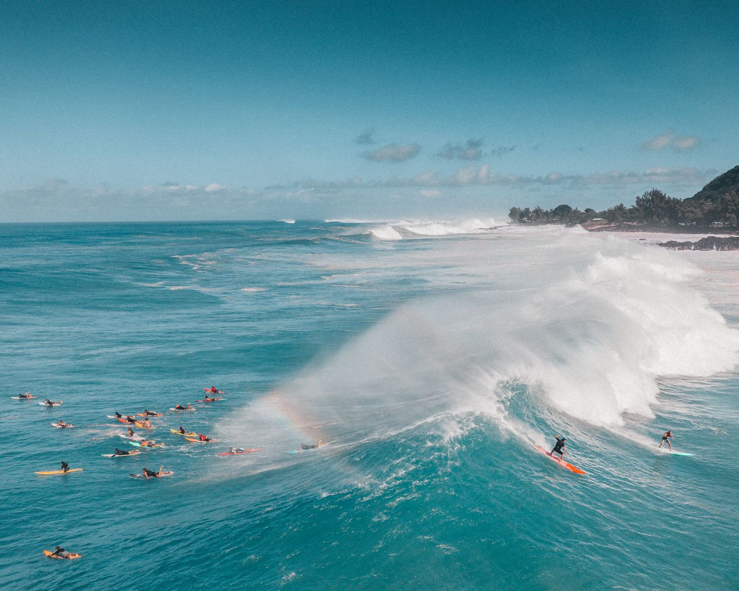 Surfers riding heavy winter waves at Waimea Bay on Oʻahu