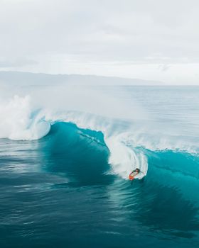 在瓦胡岛的哈雷瓦海滩，一名冲浪者熟练地冲浪，捕捉到了冒险与兴奋的精髓