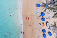 鸟瞰图捕捉了夏威夷海滩的热闹场景，冲浪者和游客点缀其间