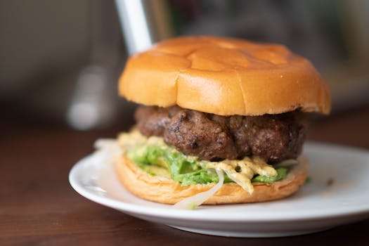 盘中盛放着令人垂涎欲滴的汉堡，配有奶酪和生菜