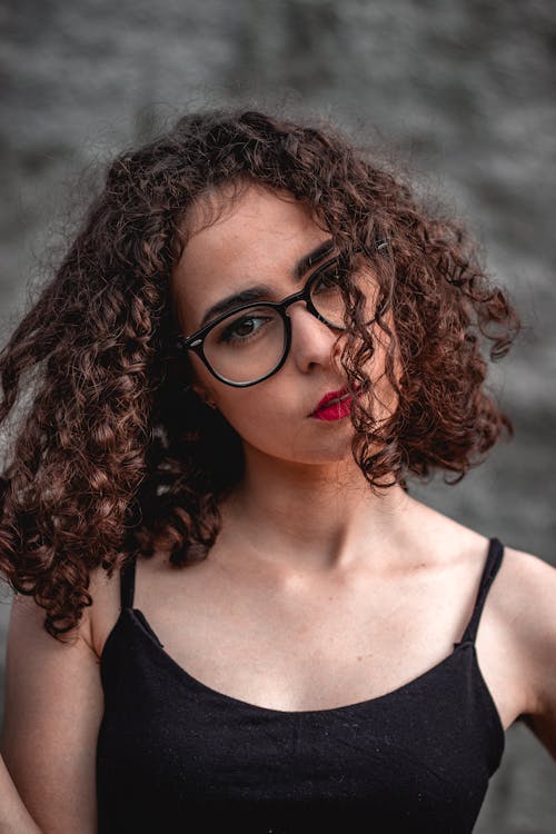 Portrait of a Brunette with Curly Hair Wearing Black Eyeglasses